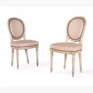 Sillas antiguas de madera con tapizado rosa pálido.