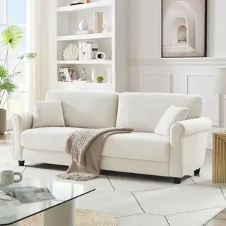 Biała sofa z narzuconym na wierzch kocem.