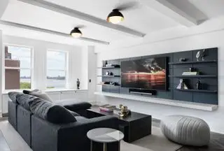 biało-szary apartament salon z telewizorem, półkami, stolikiem kawowym, dywanikiem, podnóżkami