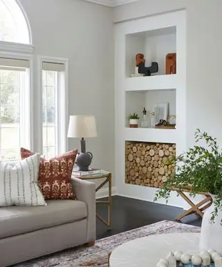 stue hvitmalt med nøytral sofa og innebygd reol med tømmerbod