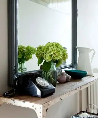 vaso de flores na mesa de console com telefone