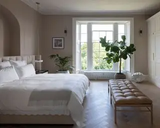 Stort master bedroom læder daybed ved fodenden af sengen, traditionelle hvide vinduer, buet alkove, indrettet skræddersyet opbevaring, stort anlæg på gulvet, parketgulve