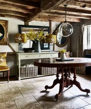 Pasillos de una antigua casa de campo con vigas, suelo de baldosas y muebles antiguos