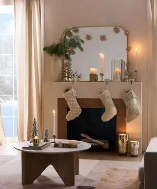 Koselig stue med levende lys og dekorert peishylle