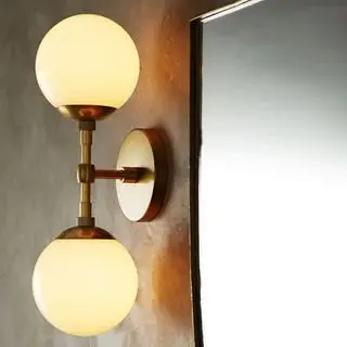 Un aplique de pared dorado con dos bombillas de ABC Home