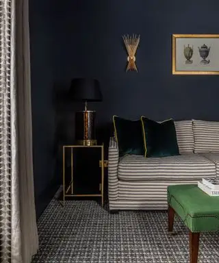 Marineblaues Wohnzimmer mit gestreiftem Sofa