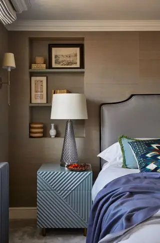 spálňa s hnedou tapetou, sivá čalúnená posteľ, výklenok/spálňa, veľká nočná lampa