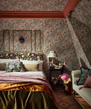 Schlafzimmer mit floraler William-Morris-Tapete an Wänden und Decke, abgerundet mit Akzenten aus roter Farbe, maximalistisches Schlafzimmerdekor