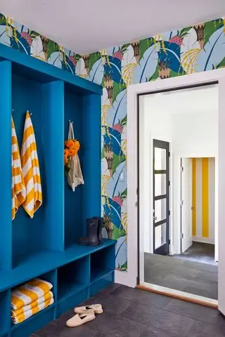 Pasillo colorido, con gabinetes hechos a medida de color azul brillante, papel tapiz estampado y notas de rayas amarillas