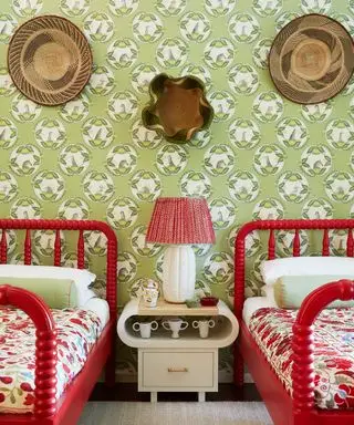 Dormitorio de lujo con papel pintado estampado y camas rojas.