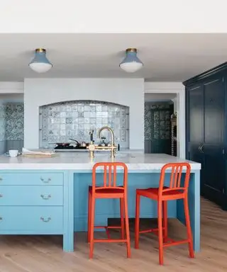 ideas de colores de isla de cocina, cocina azul con isla de cocina azul cielo, gabinetes azul oscuro, taburetes de bar rojos, colgantes azules, protector contra salpicaduras de azulejos, grifos de latón