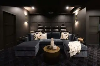 映画館の座席、ソファ、暗い壁、壁掛け照明を備えた小さなメディア ルーム