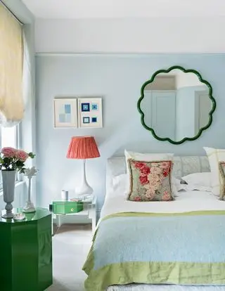 camera da letto blu pallido con uno specchio sopra il letto