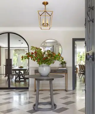 entrada com mesa e vaso de flores