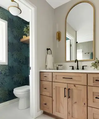 Salle de bain beige avec papier peint vert foncé