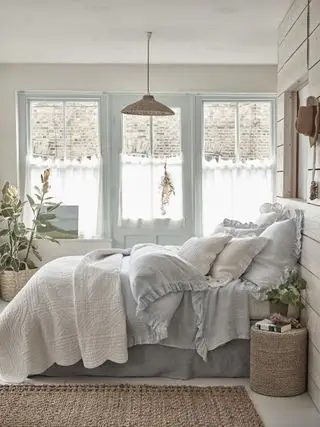 dormitorio azul y blanco con ropa de cama de color azul pálido, carpintería azul en ventanas y puertas