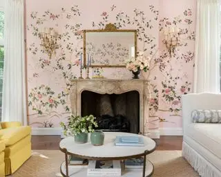 Bonito salón rosa con papel tapiz floral y chimenea decorada