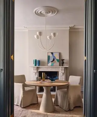 Comedor moderno con mesa redonda y repisa decorada.