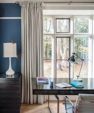Idéias para cortinas de janela grande com cortinas cinza em um escritório azul com mesa preta e cadeira cinza