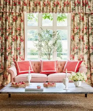 Idéias para cortinas de janela grande com cortinas com motivos florais e saia atrás de um sofá com almofadas rosa