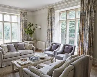 Idéias para cortinas de janela grande com cortinas estampadas pesadas em uma sala de estar neutra
