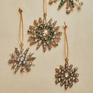 Adornos dorados para árboles de Navidad con copos de nieve.