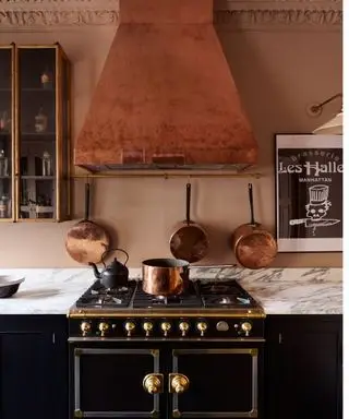 cucina nera e rosa con cappa rame e accessori devol