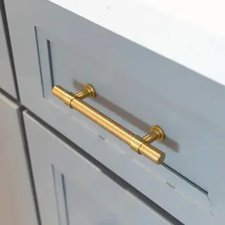 Um armário azul com um longo puxador de porta dourado
