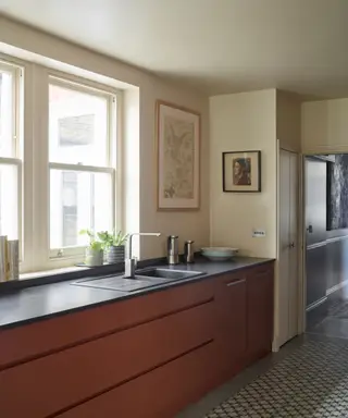 Uma cozinha com uma grande janela e armários marrons