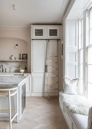 Cuisine blanche avec rangements du sol au plafond et échelle