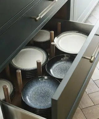 åben køkkenskuffe med plader indeni