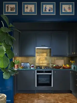 Lite blått kjøkken med metallisk splashback