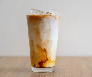 Café glacé dans un verre sur une table en bois