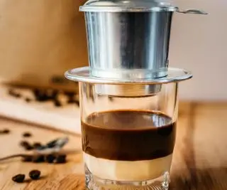 café vietnamien avec le phin sur le dessus et les haricots en arrière-plan