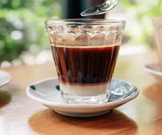 café vietnamien dans un verre, sur une soucoupe, sur une table en bois