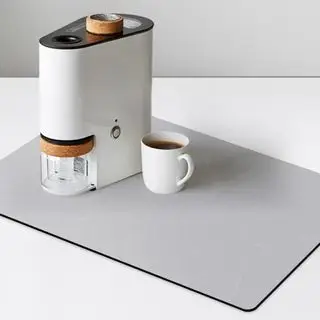 Alfombra de café gris con una cafetera y una taza de café encima