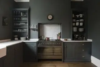 Cocina Devol con paredes gris oscuro y gabinetes gris oscuro.