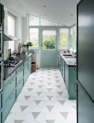 Cozinha pequena com piso hexagonal e armários azuis