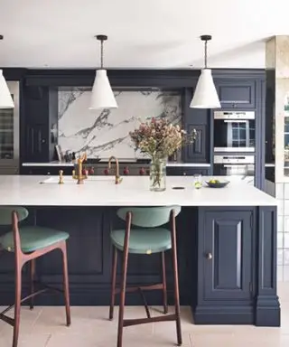 מטבח עם ארונות כחולים כהים ו-backsplash משיש