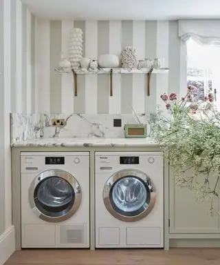 Machine à laver Miele dans une buanderie chic de style ferme avec papier peint à rayures et fleurs dans l'évier
