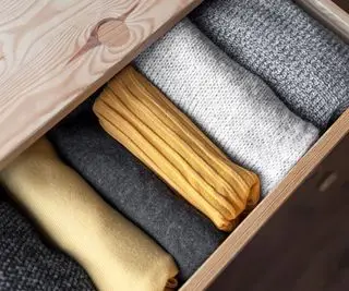 Archivar la ropa doblada organizada en un cajón de cómoda