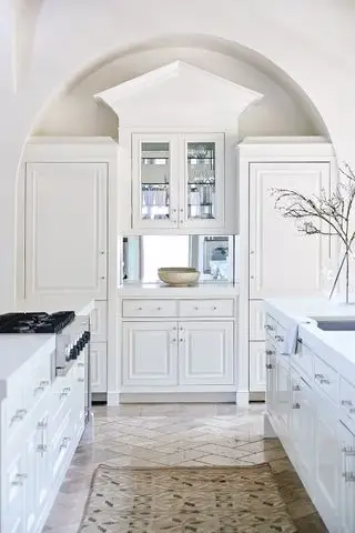 cozinha branca com bela arquitetura e armários e tapete no chão