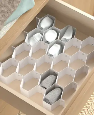 회색 서랍장과 등받이가 높은 안락의자가 있는 침실