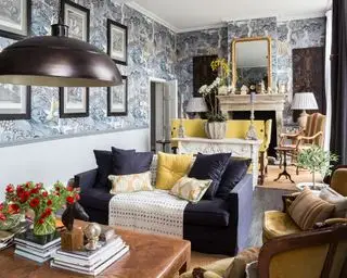 Idea de sala de estar larga con papel tapiz estampado en azul y muebles alejados de las paredes.