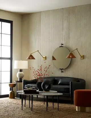 Sala de estar neutra con sofá Arteriors negro y detalles en pimentón