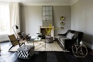Salón gris con sofá de terciopelo negro.
