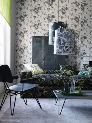 Salón floral con sofá floral negro.