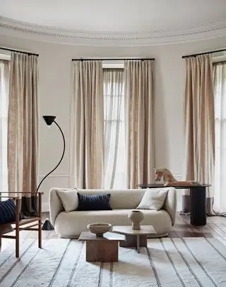 Nøytral stue med beige sofa og beige gardiner