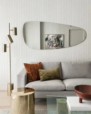 Beige stue med beige sofa, terrakotta fløyelspute og kaldt sidebord