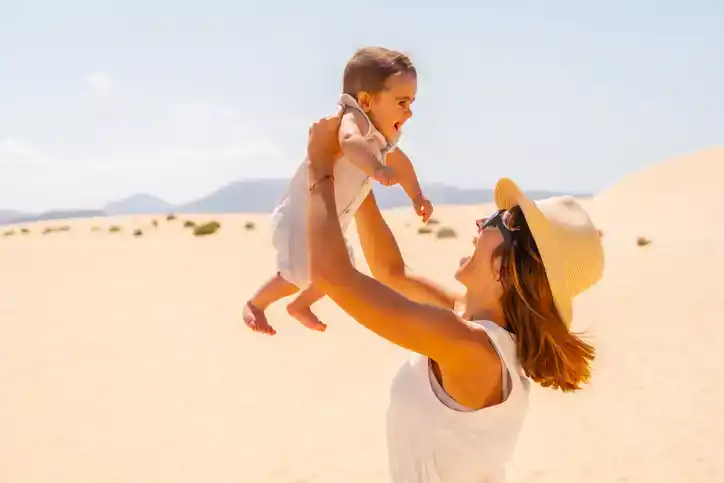 Young mother playing with her son on vacation in the dunes